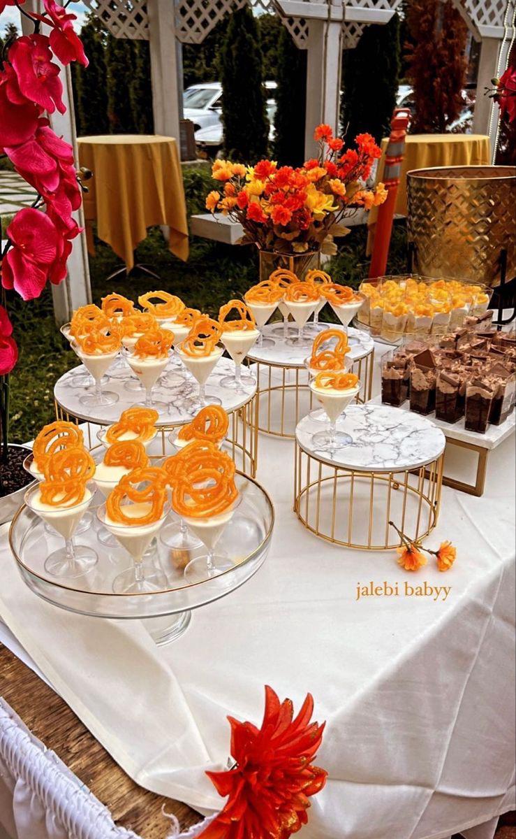 Jalebi-topped desserts displayed in glasses with flowers