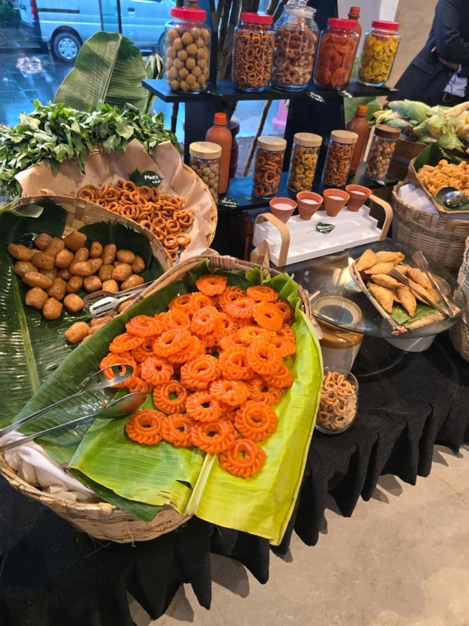 Indian sweets and snacks displayed on banana leaves
